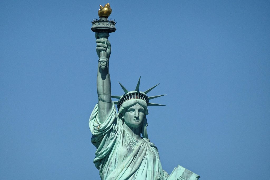 Detailed close-up of the Statue of Liberty against a clear blue sky in New York City.